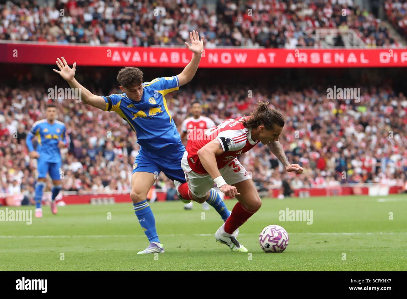 23 agosto 2025; Emirates Stadium, Londra, Inghilterra; Premier League Football, Arsenal contro il Leeds United; Riccardo Calafiori dell'Arsenal cade sotto la sfida di Daniel James del Leeds United nell'area di rigore e vuole un rigore ma non viene dato nulla Foto Stock