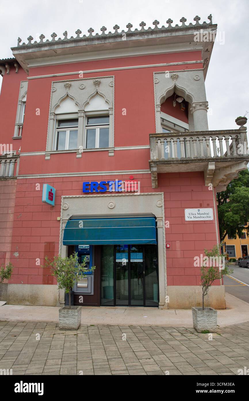 Novigrad, Croazia - 22 maggio 2025: Moderna filiale di Erste situata al piano terra di un palazzo gotico veneziano decorato con archi a punta e decorazioni Foto Stock