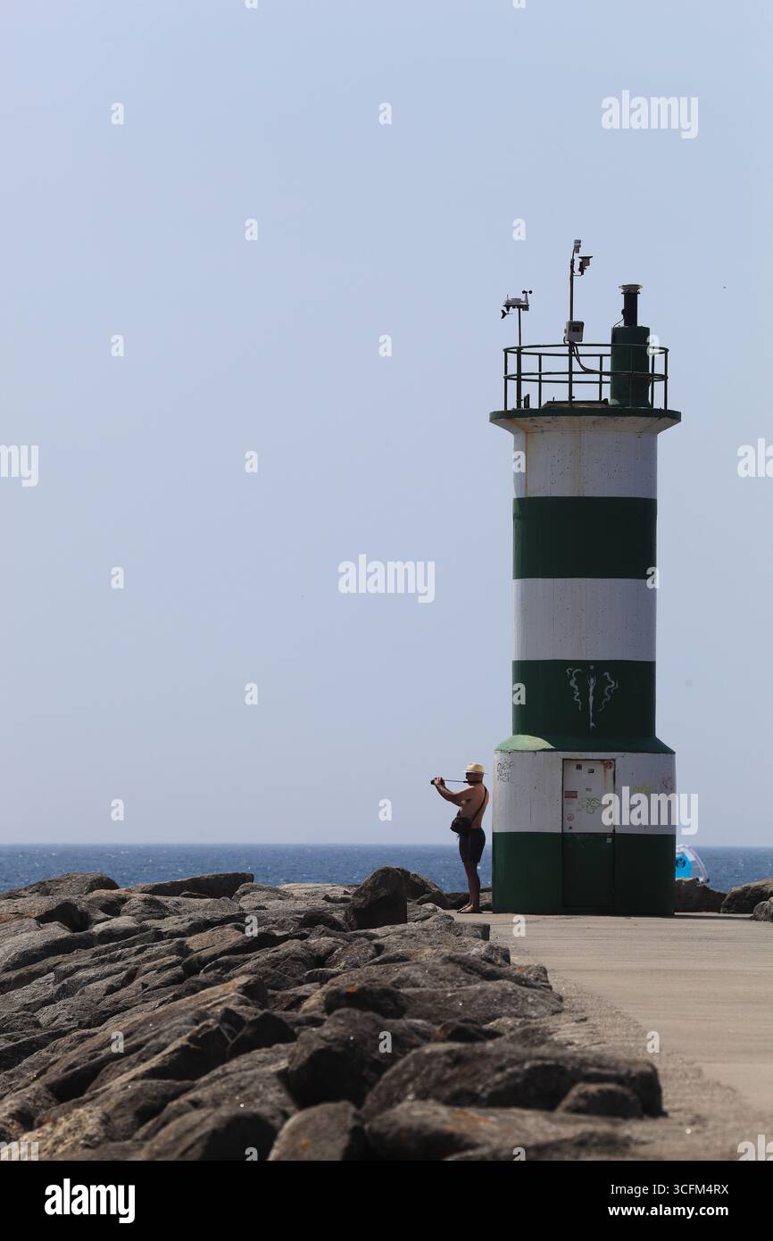 Cabedelo, Viana do Castelo, Portogallo - 21 agosto 2025: Un uomo che scatta foto vicino al faro dell'Oceano Atlantico Foto Stock