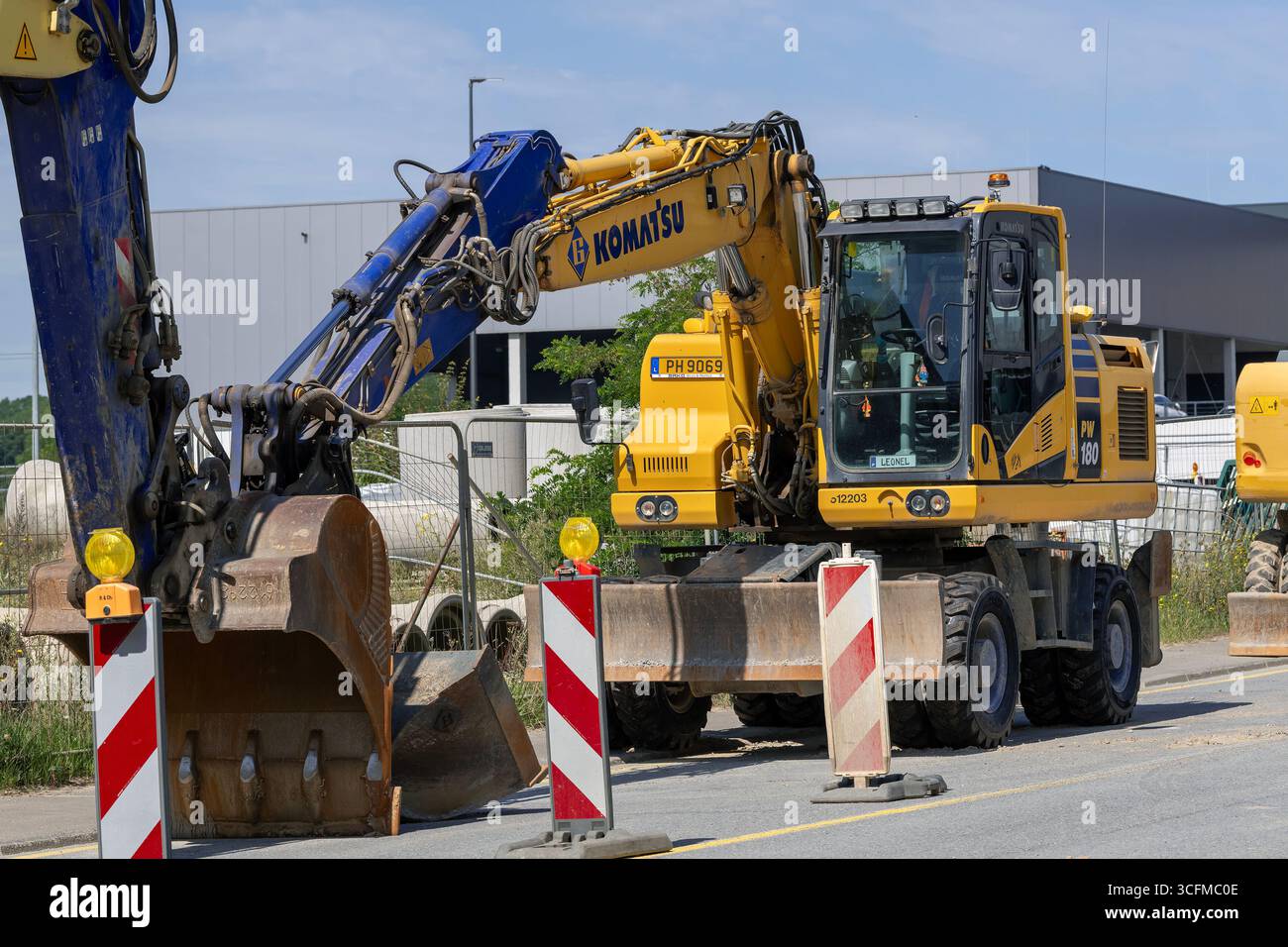 Wickrange, Lussemburgo - Vista su un escavatore gommato giallo Komatsu PW180-11 per lavori in terra in cantiere. Foto Stock