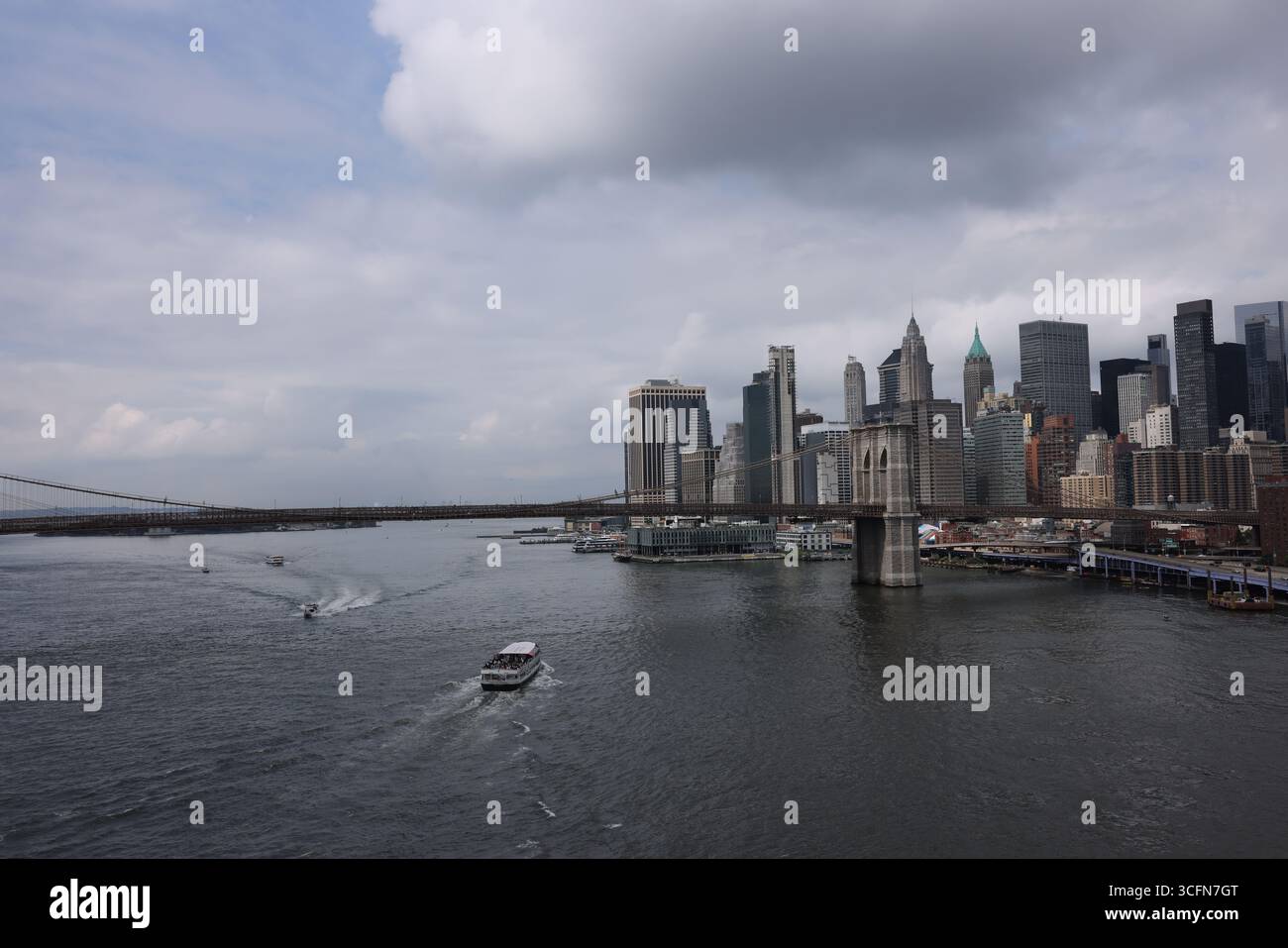 Manhattan, New York. Presa il 15 luglio 2025. Lower Manhattan Skyline in una nuvolosa giornata estiva con vista sul fiume est e sul ponte di Brooklyn. Foto Stock