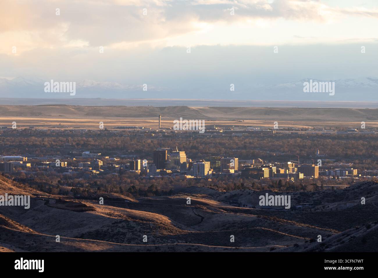 Una città è visibile in lontananza con una catena montuosa nel bosco Foto Stock