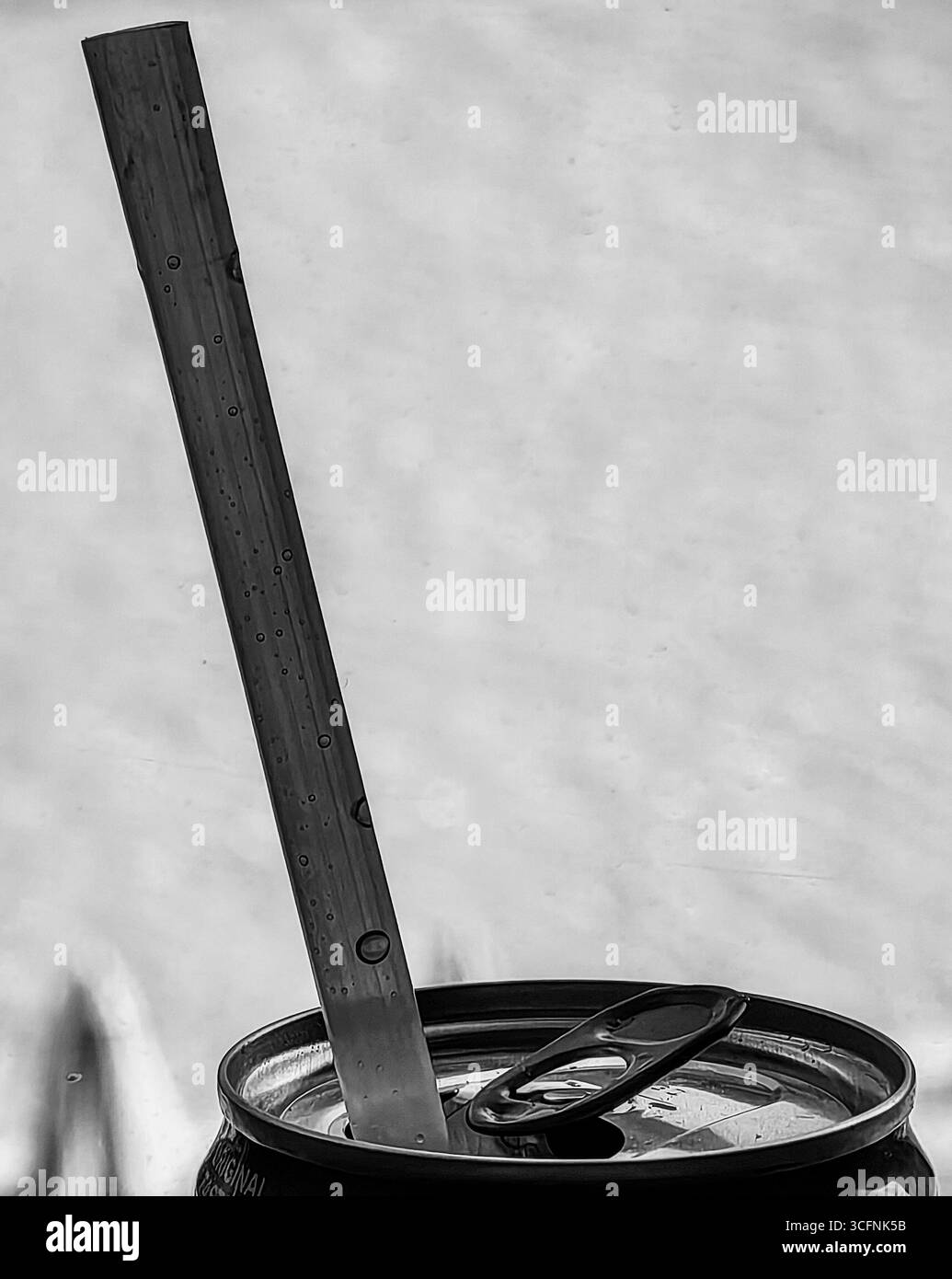 Paglia su lattina di bibite presso la piscina. Tonalità monocromatiche. Foto Stock