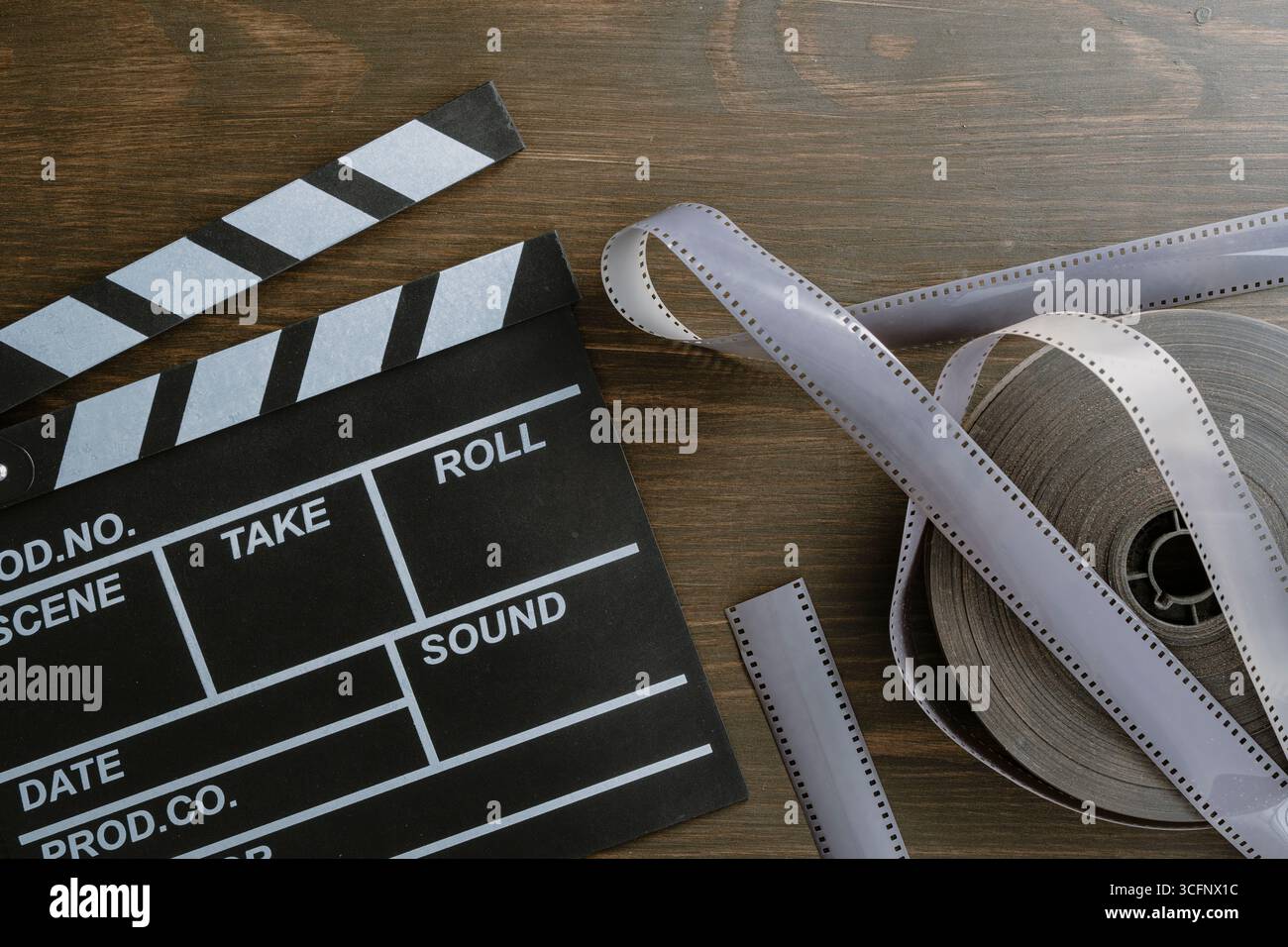 Foto d'epoca di clapper cinematografico e pellicola su sfondo in legno, primo piano, vista dall'alto Foto Stock