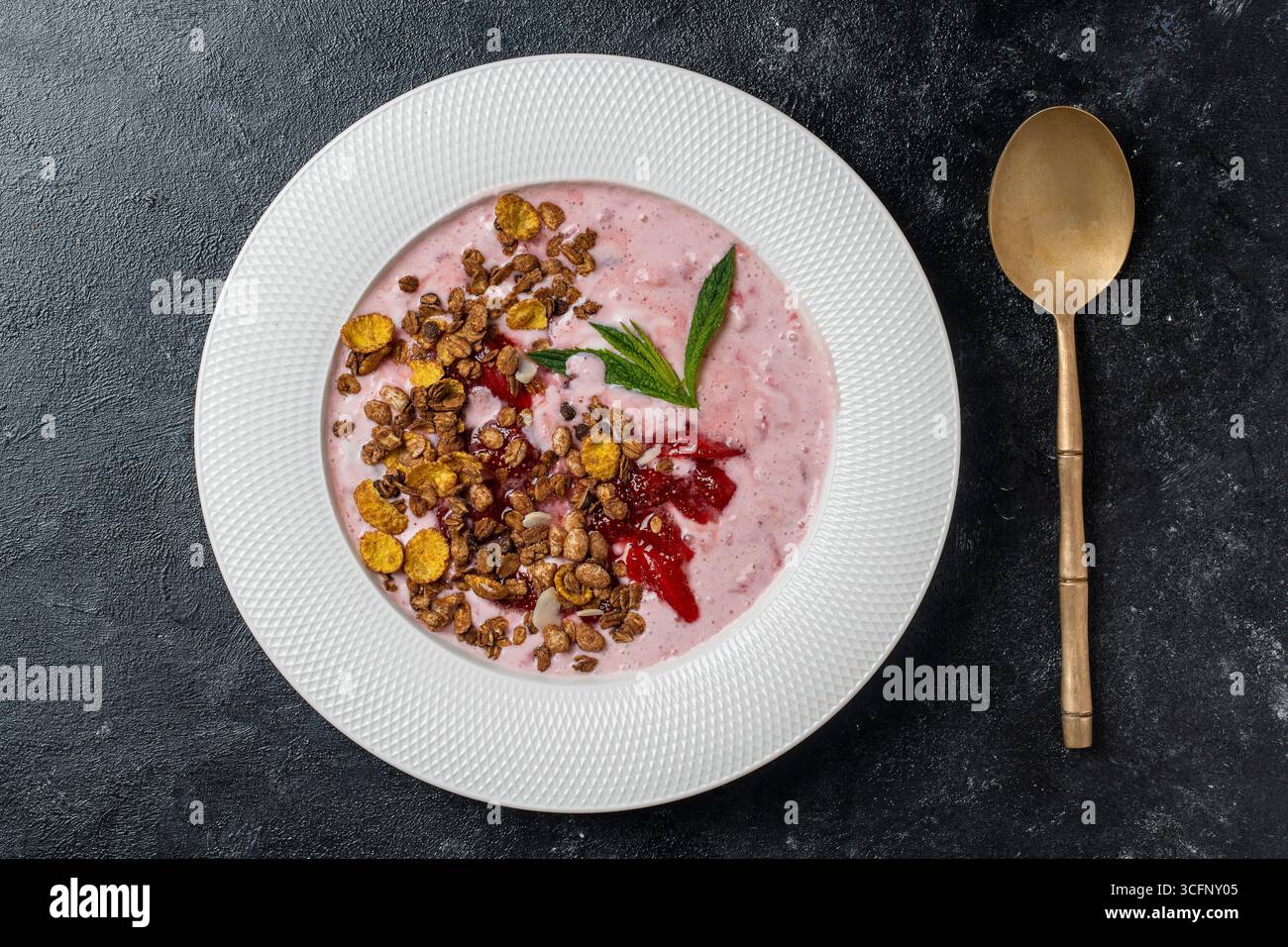 Piatto bianco con fragole rosse, granola e yogurt naturale su sfondo nero, da vicino, vista dall'alto Foto Stock