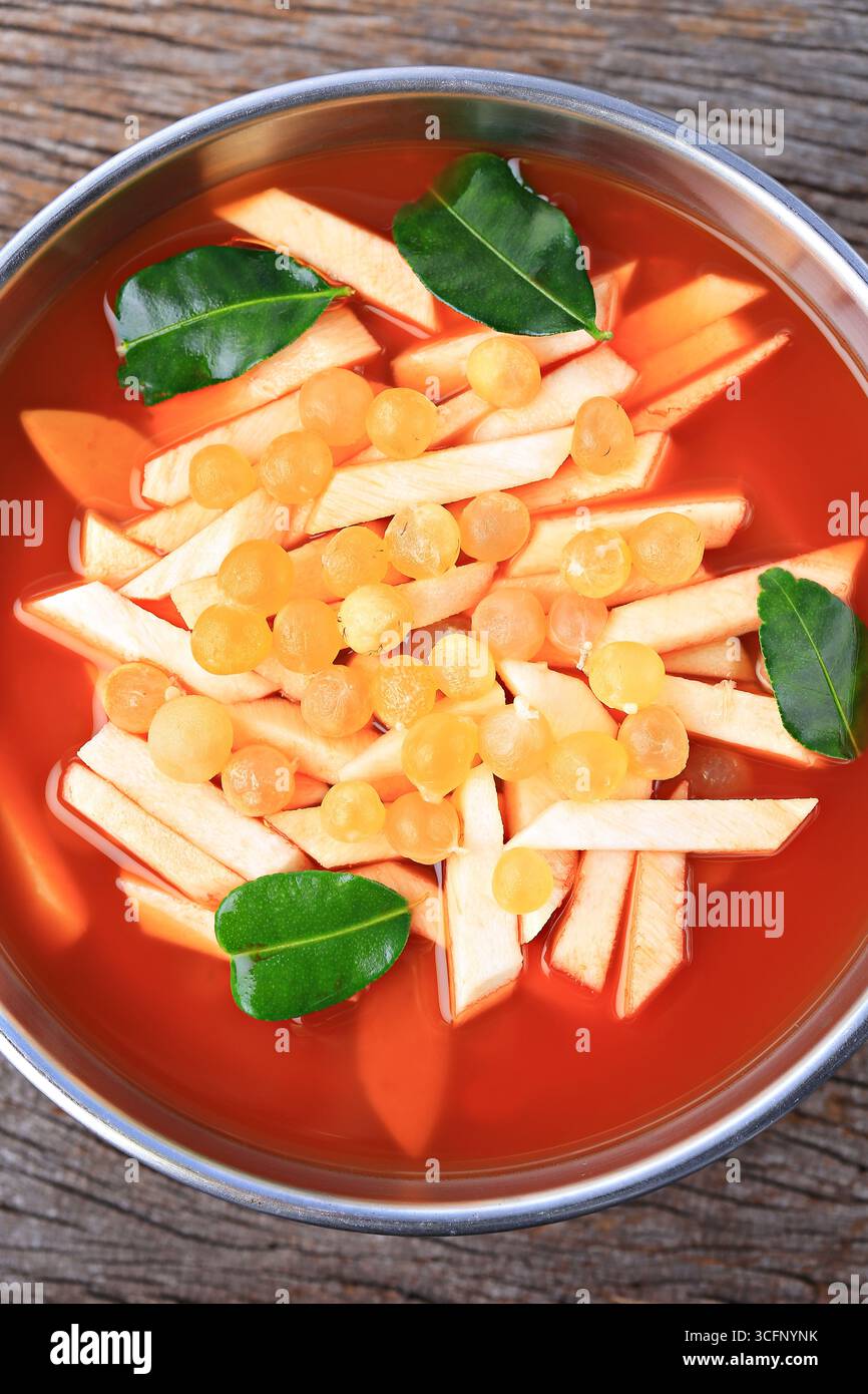 Zuppa piccante e acida in stile thailandese con germogli di cocco giovani e radice di pesce gatto gigante in Hot Pot Foto Stock
