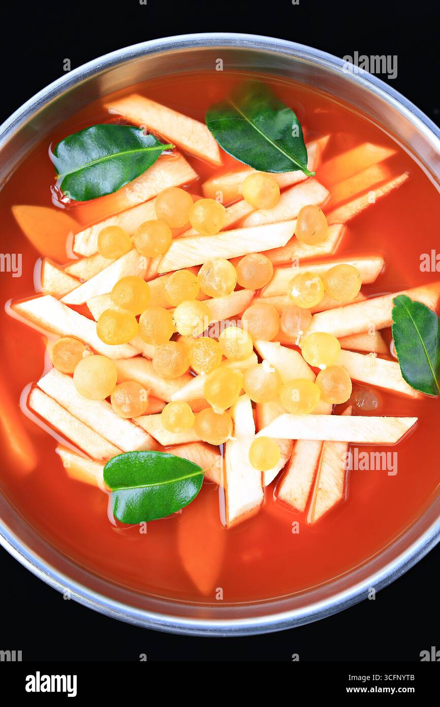 Zuppa piccante e acida in stile thailandese con germogli di cocco giovani e radice di pesce gatto gigante in Hot Pot Foto Stock