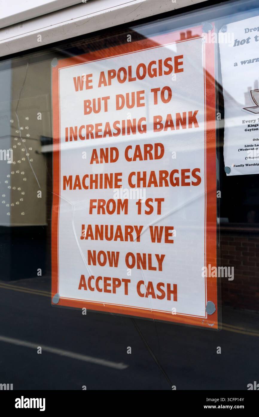 Un cartello su un negozio di fish & chip dice che, a causa dell'aumento delle spese di banca e bancomat, ora accettano solo contanti. Foto Stock