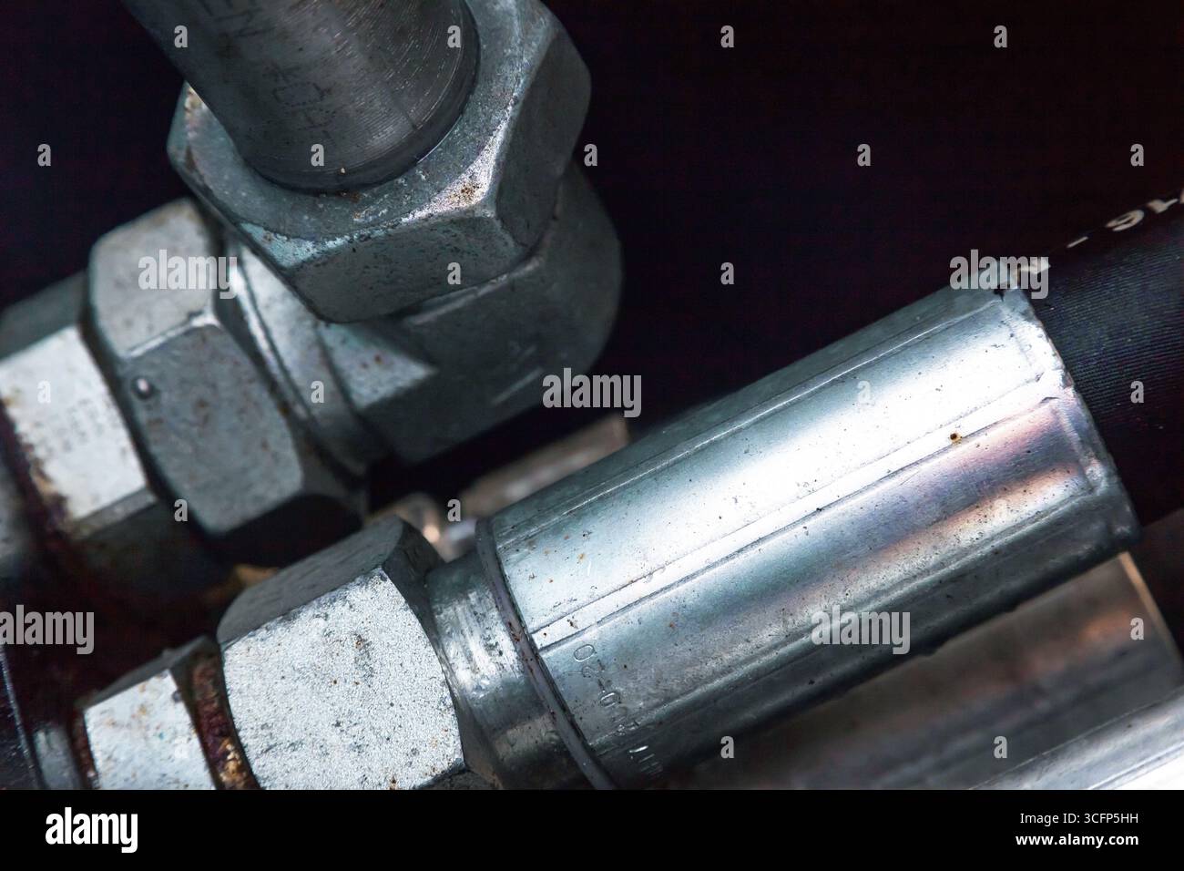 Sistema di tubi flessibili idraulici ad alta pressione collegato a tubi in acciaio, primo piano. Impianto idraulico marino. Foto Stock