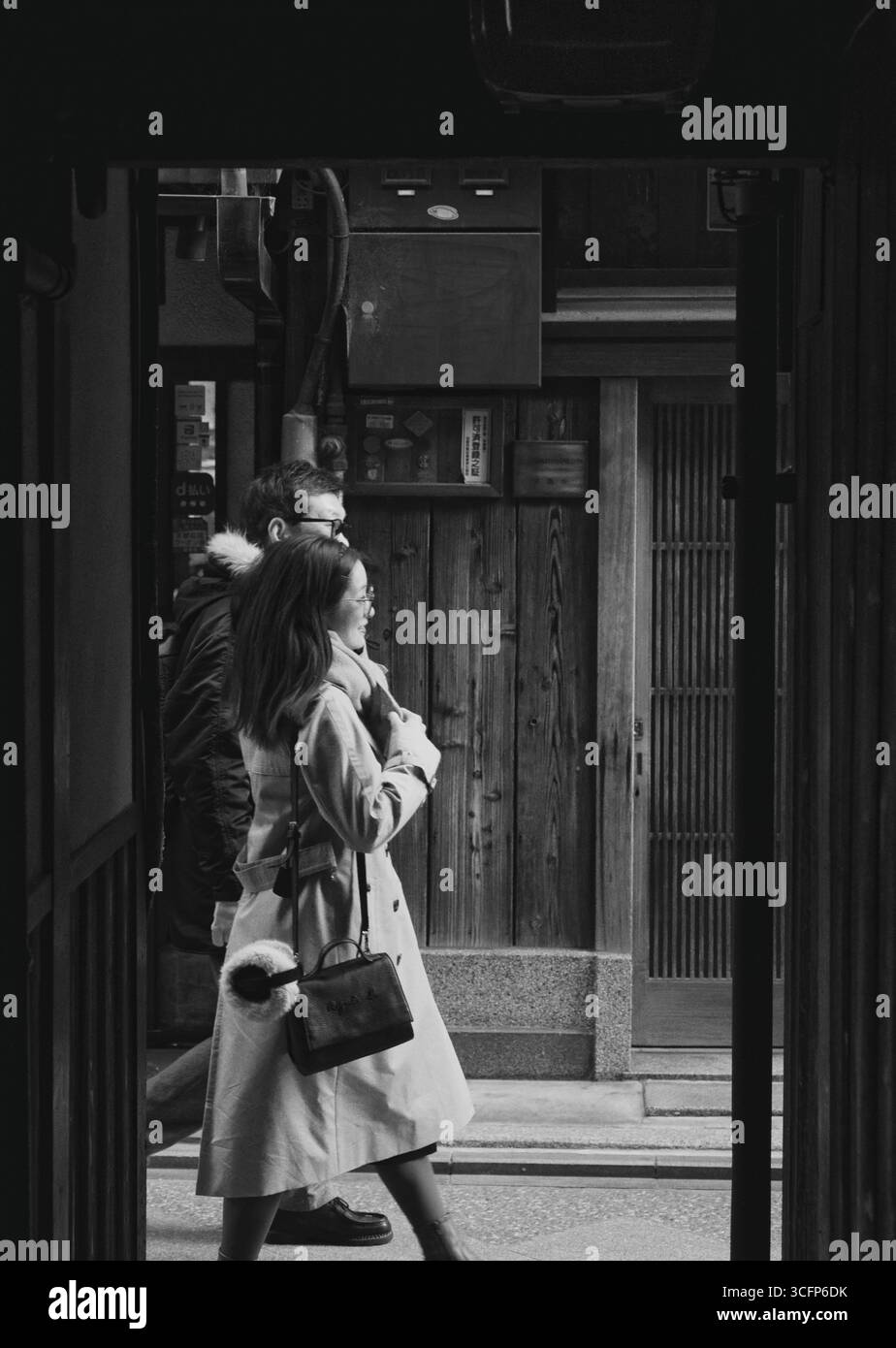 Foto in bianco e nero di un movimento di coppia sfocato passeggiando per le famose stradine della zona di Pontocho a Kyoto Foto Stock