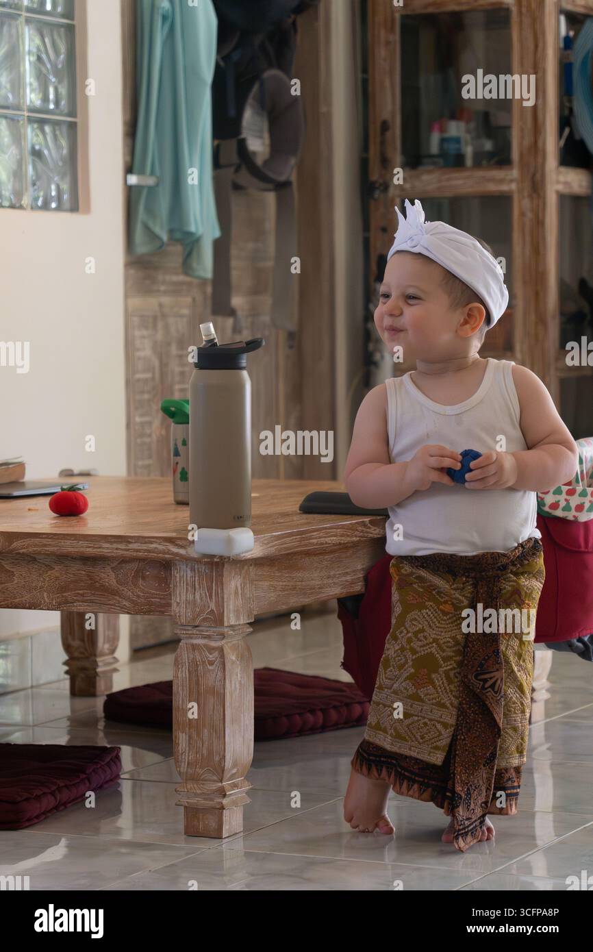 Il bambino maschile gioca con i giocattoli all'interno della casa Foto Stock