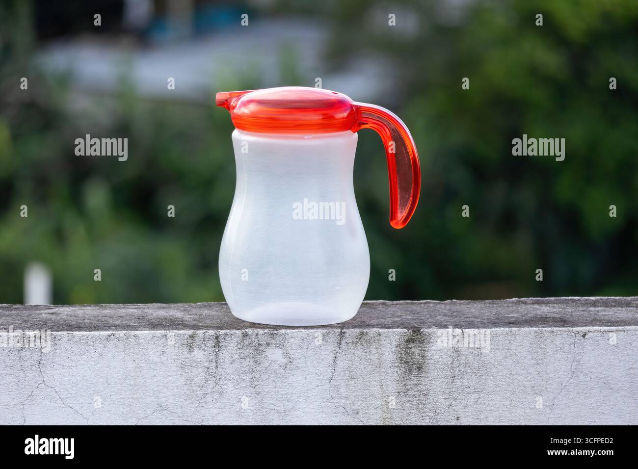 Svuotare il recipiente dell'olio in plastica su una parete ruvida e resistente agli agenti atmosferici con sfondo bokeh. Foto Stock