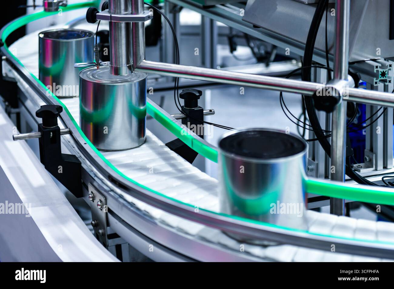 Prodotti alimentari in scatola su nastro trasportatore nel magazzino di distribuzione. Concetto del sistema di trasporto alimentare Foto Stock