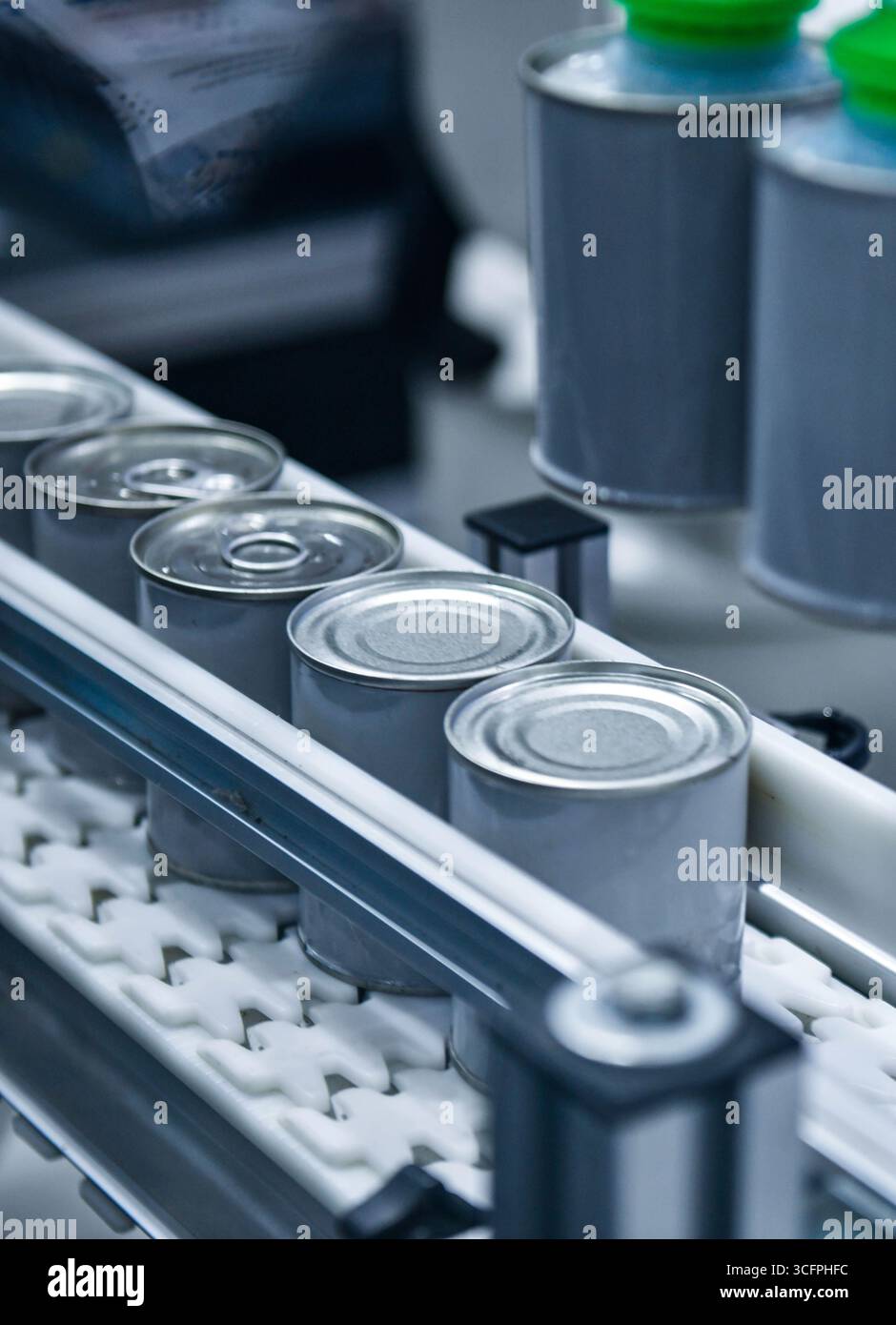 Prodotti alimentari in scatola su nastro trasportatore nel magazzino di distribuzione. Concetto del sistema di trasporto alimentare Foto Stock