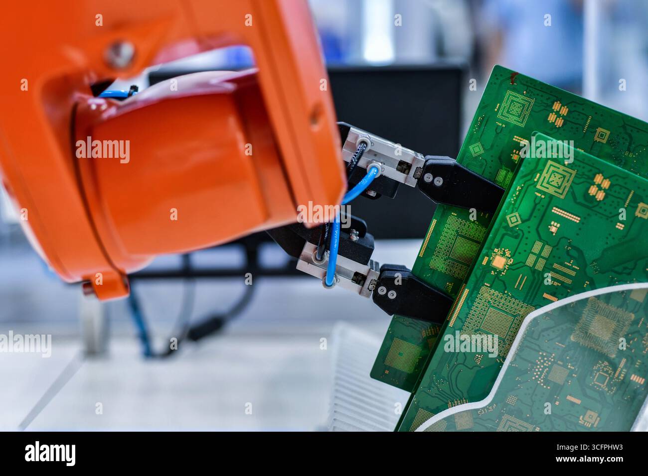 Moderno sistema di automazione del braccio robot che sposta i circuiti stampati in una fabbrica, concetto di robot industriale Foto Stock