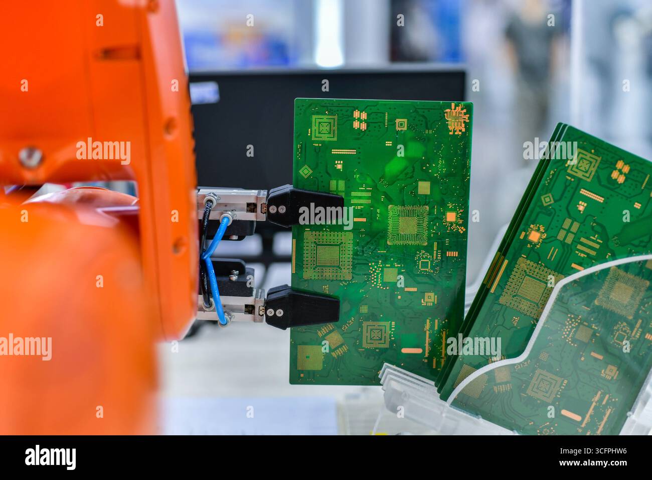 Moderno sistema di automazione del braccio robot che sposta i circuiti stampati in una fabbrica, concetto di robot industriale Foto Stock