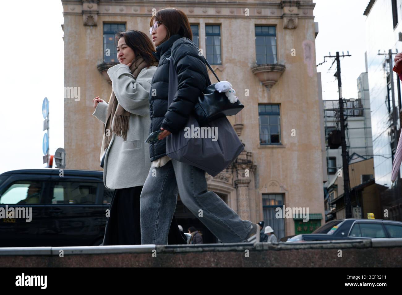 Le donne passano accanto a Tōka Saikan, uno storico ristorante in stile barocco degli anni '1920 accanto al fiume Kamo di Kyoto Foto Stock