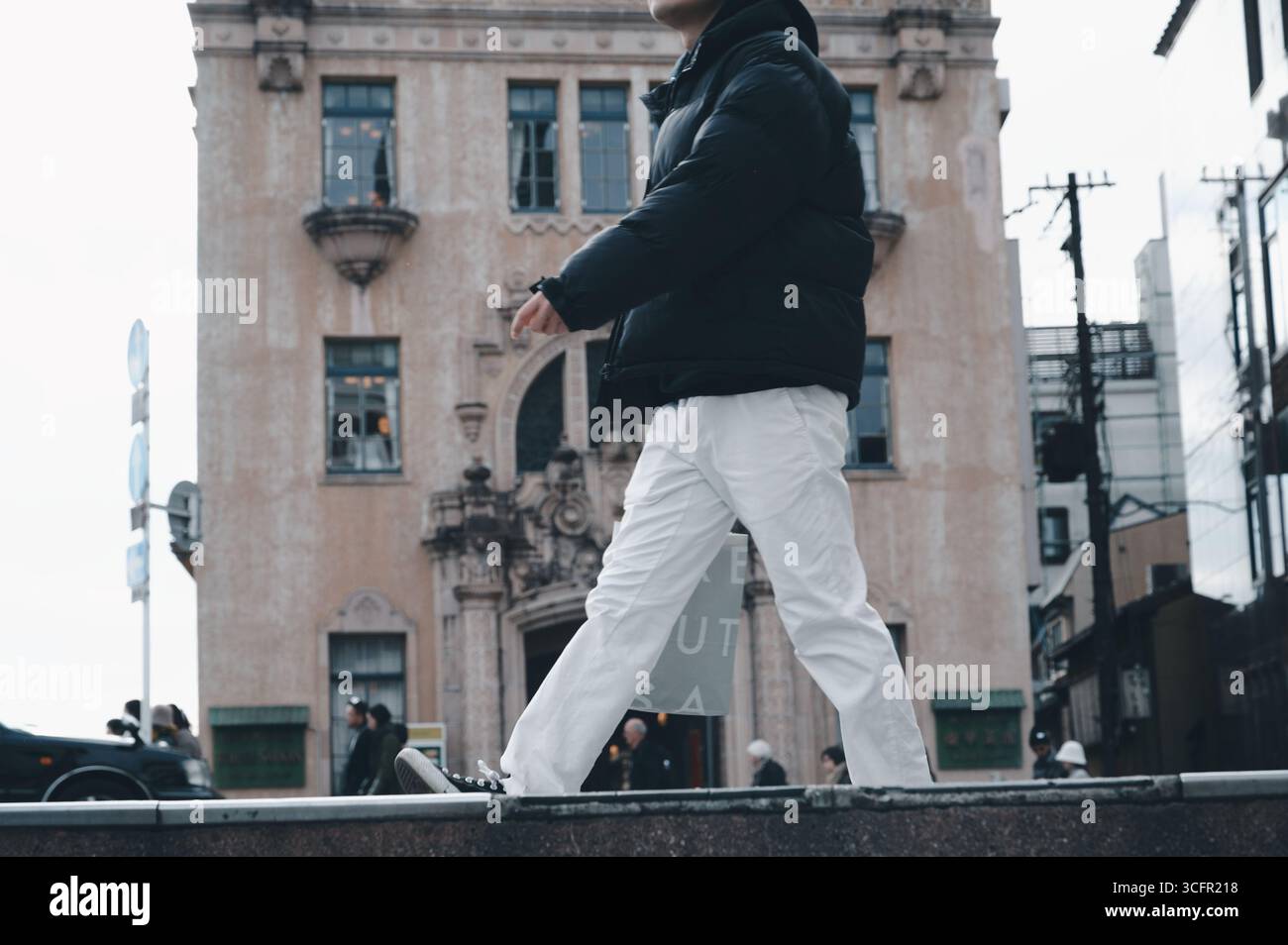 L'uomo passa accanto a Tōka Saikan, uno storico ristorante in stile barocco degli anni '1920 accanto al fiume Kamo di Kyoto Foto Stock
