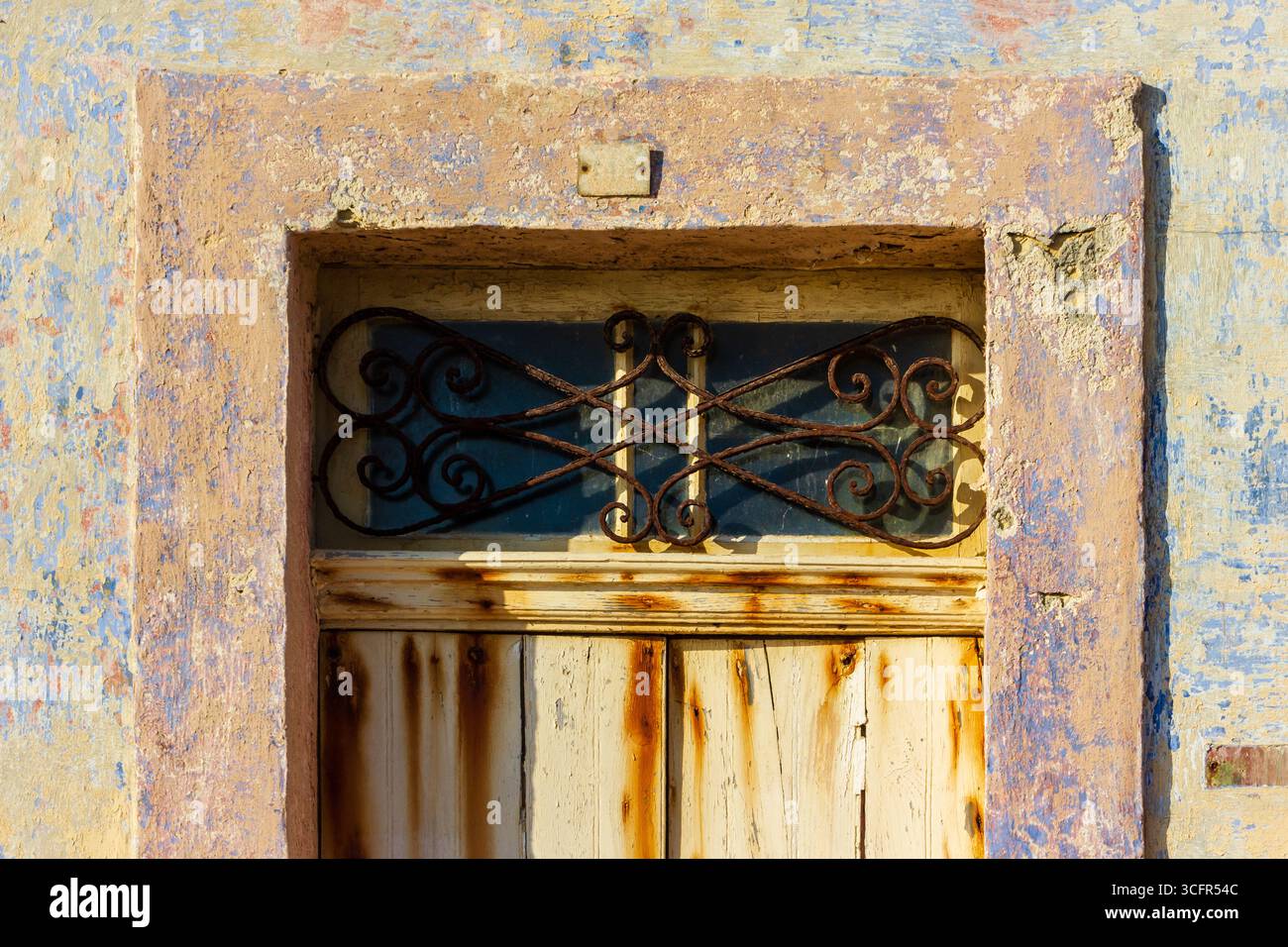 Portiera rustica invecchiata con vernice effetto angosciato e decorazioni metalliche sopra la testa Foto Stock