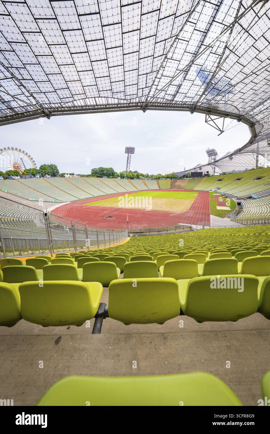 Stadio moderno e vuoto con vista centrale sulla pista da corsa e sulla suggestiva architettura in vetro, Olympiapark, Monaco, Germania Foto Stock