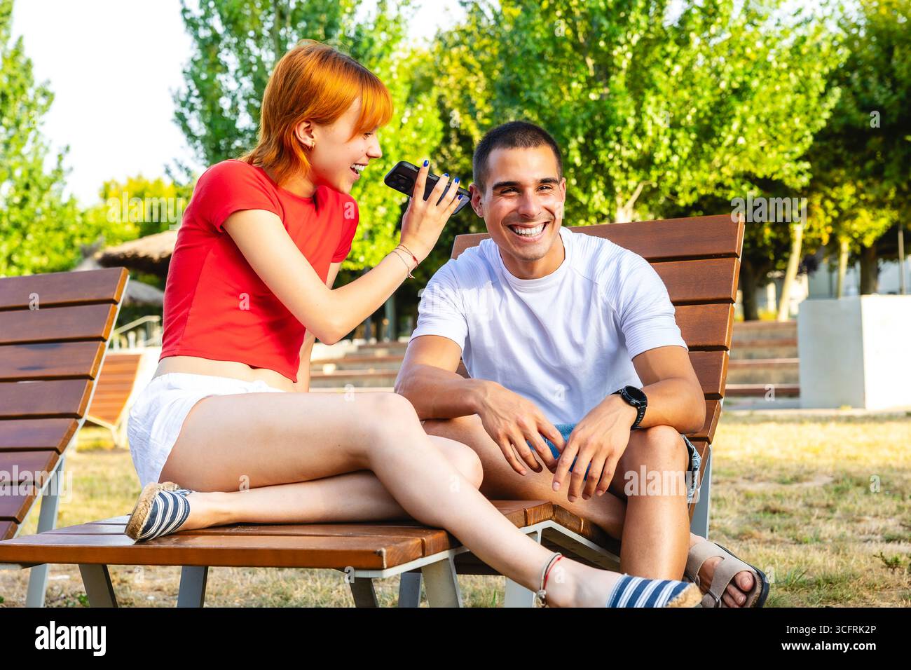 Giovani coppie che condividono musica all'aperto il giorno d'estate Foto Stock