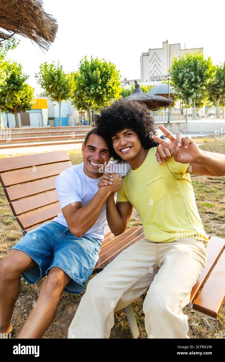 Due amici che sorridono e si divertono in un parco cittadino Foto Stock
