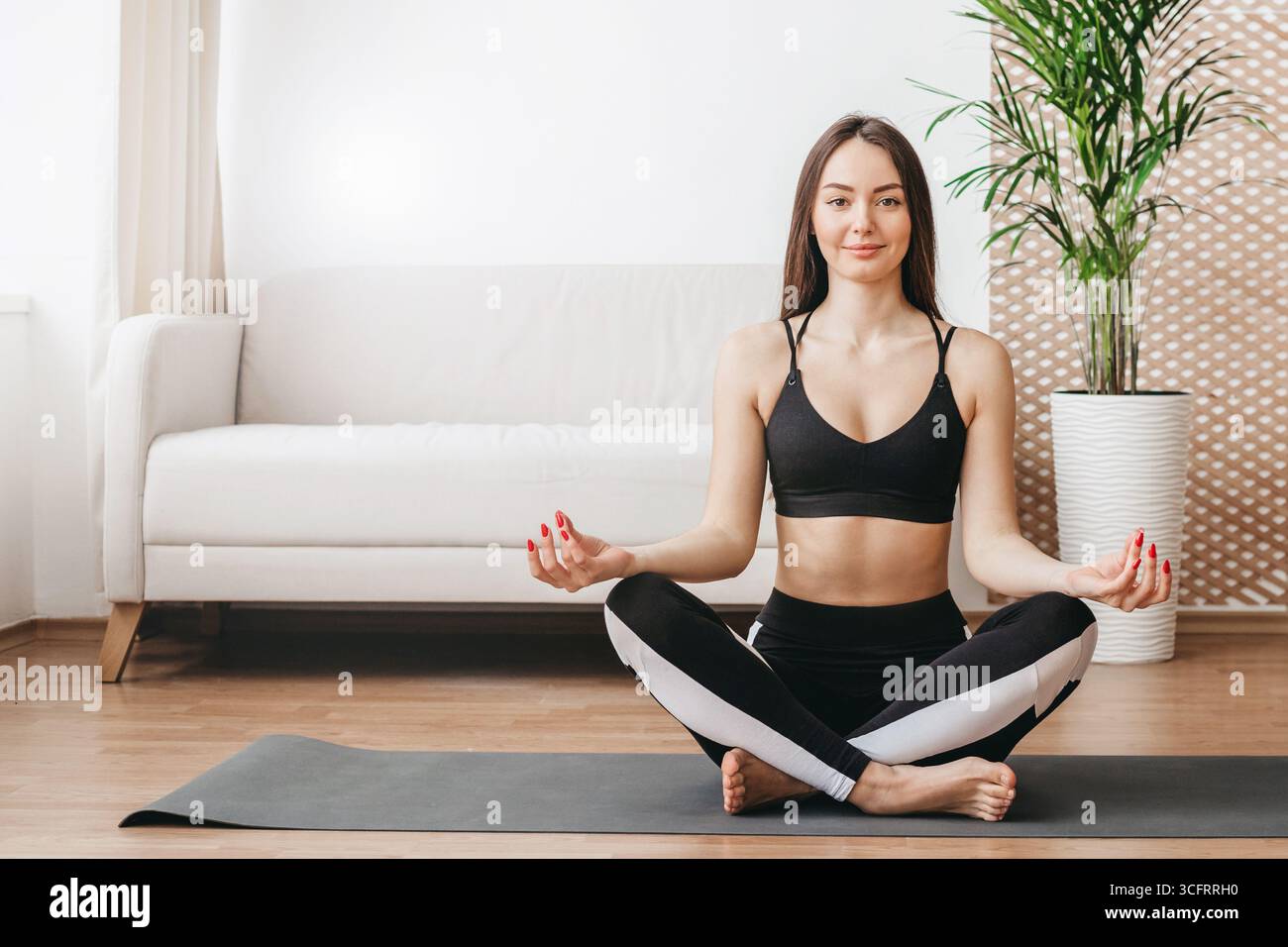 Giovane donna caucasica che fa yoga mattutino a casa. Meditazione per anima e corpo. concetto di stile di vita sano. copia spazio Foto Stock