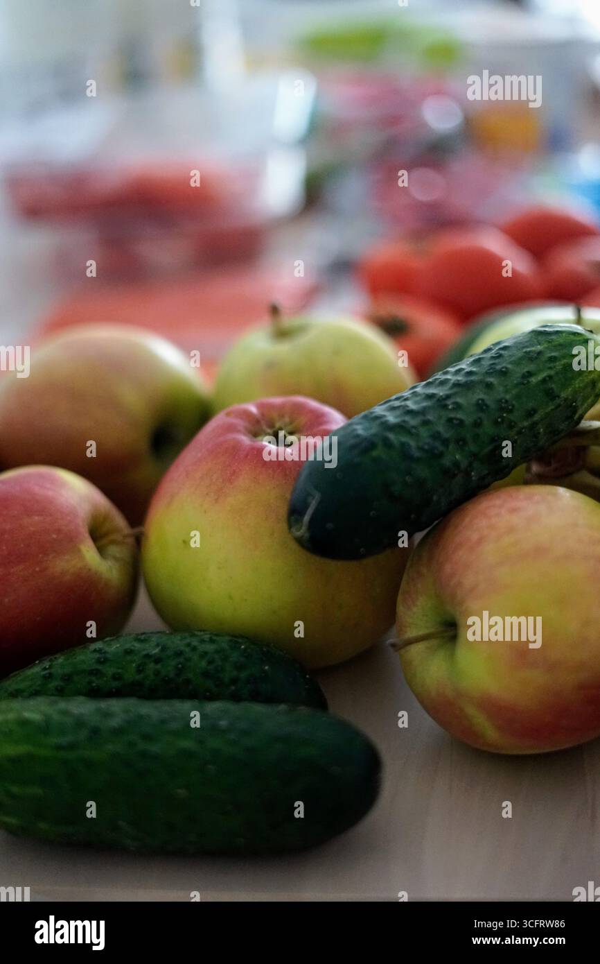 Una selezione di frutta e verdura fresche disposte su una superficie di legno Foto Stock
