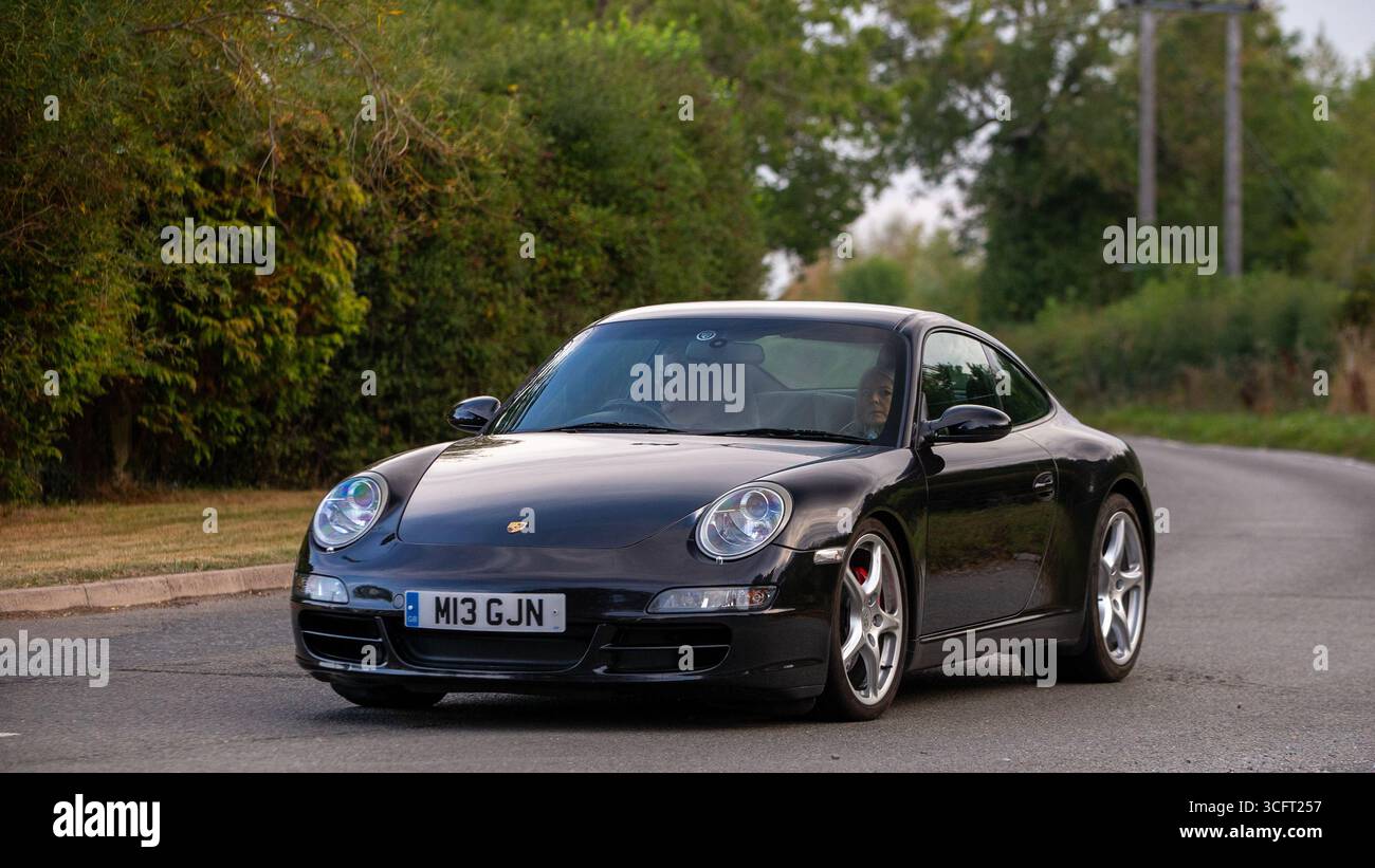 Whittlebury, Norhants, Regno Unito - 23 agosto 2025: 2005 Porsche 911 nera che guida su una strada britannica Foto Stock