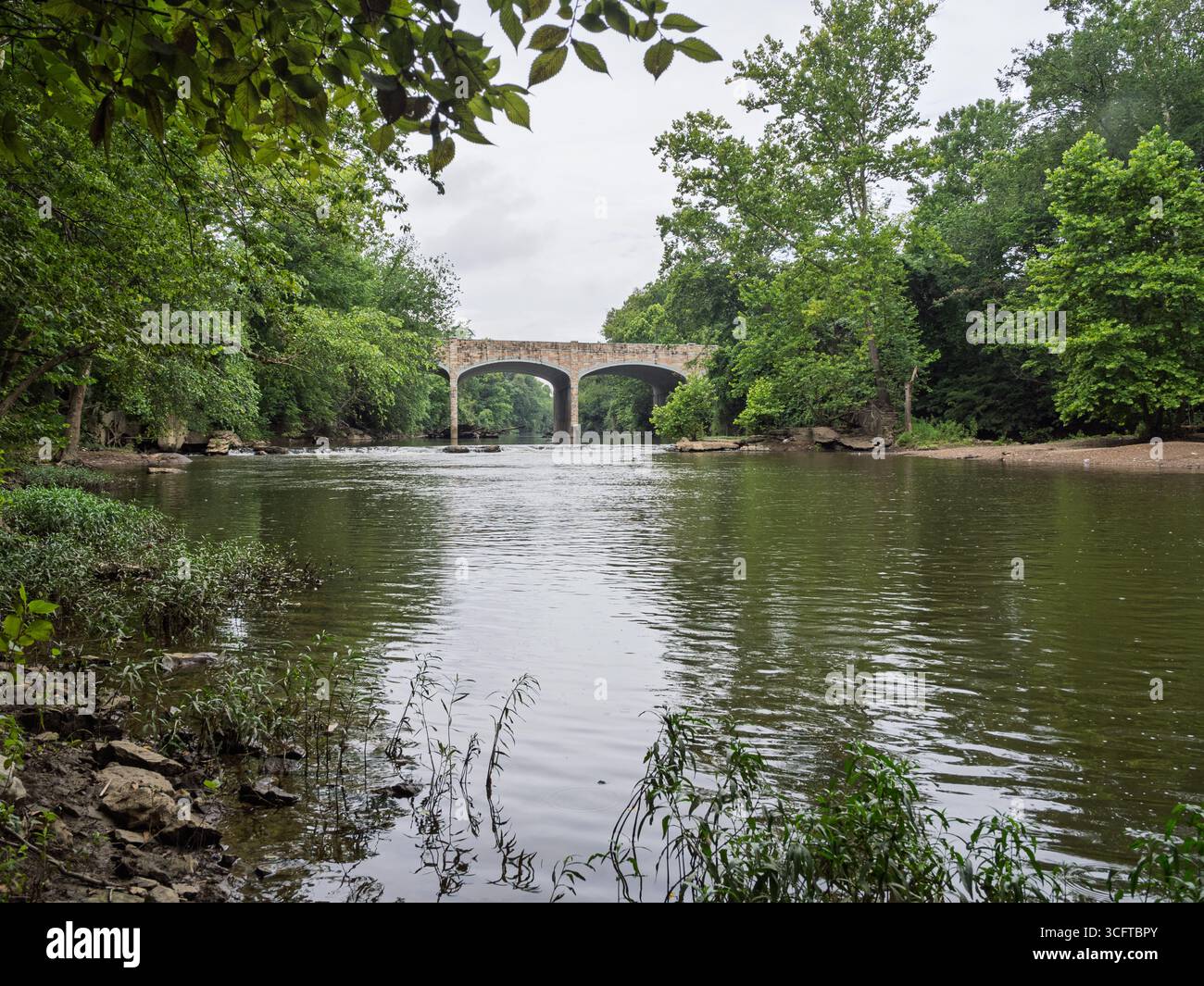 Lo storico New Coton Bridge, un bellissimo ponte ad arco in pietra che si estende sulle tranquille acque di Goose Creek. Foto Stock