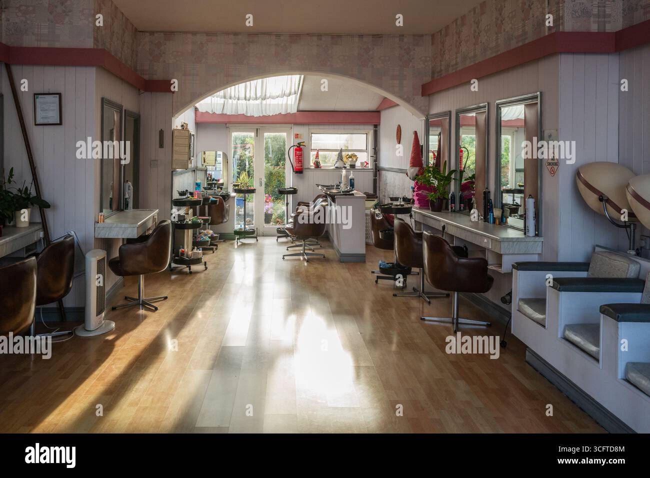 Sunlight and Shadows: Uno sguardo a un parrucchiere in stile vintage anni '1960 a Bridport, Dorset. Concetto - retro. Foto Stock