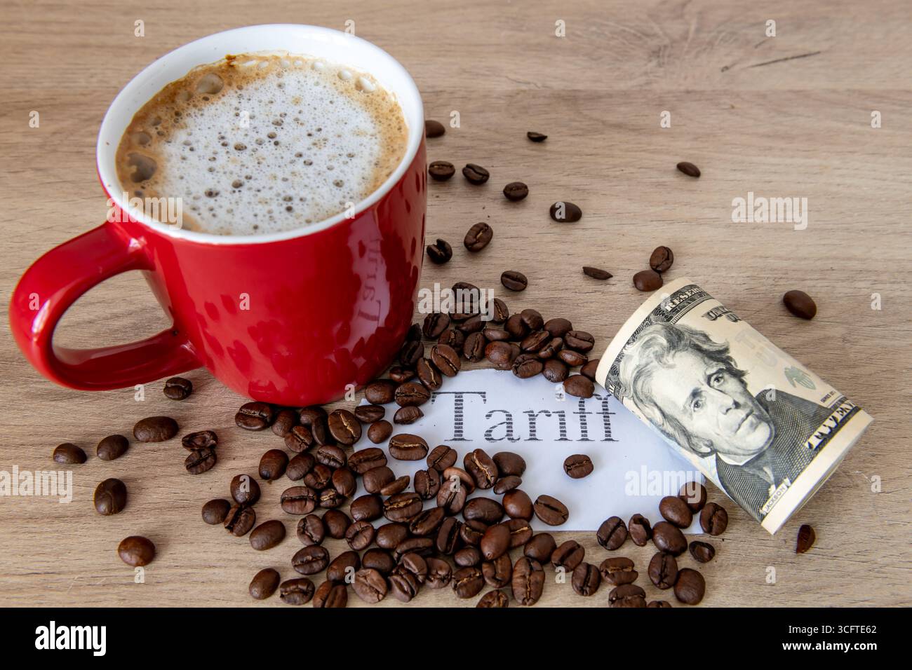 Una tazza di caffè, chicchi di caffè, la tariffa stampata e un rotolo di banconote da dollari americani su un tavolo. Un concetto di tariffa per il caffè. Foto Stock