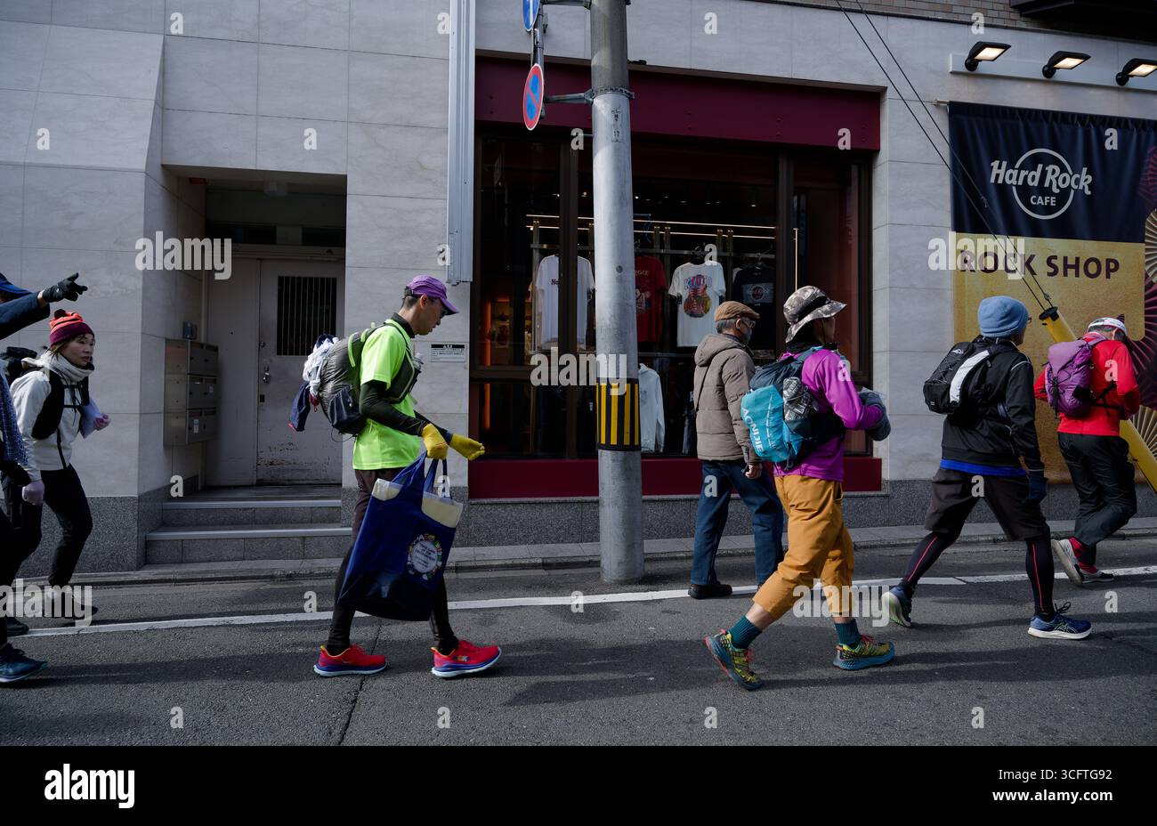 Un gruppo di escursionisti in abiti colorati passa accanto all'Hard Rock Café Rock Shop di Kyoto Foto Stock