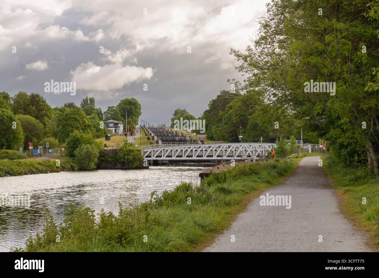 Una vista lungo il sentiero della città accanto al Canale Caledoniano (la Great Glen Way) verso il Ponte Swing della ferrovia Banavie e la Scala di Nettuno Foto Stock