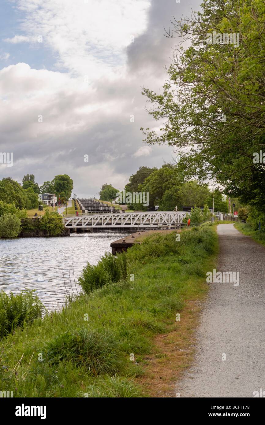 Guardando verso il Banavie Swing Bridge e la serie di chiuse conosciuta come Scala di Nettuno dal sentiero della città accanto al canale Caledoniano Foto Stock