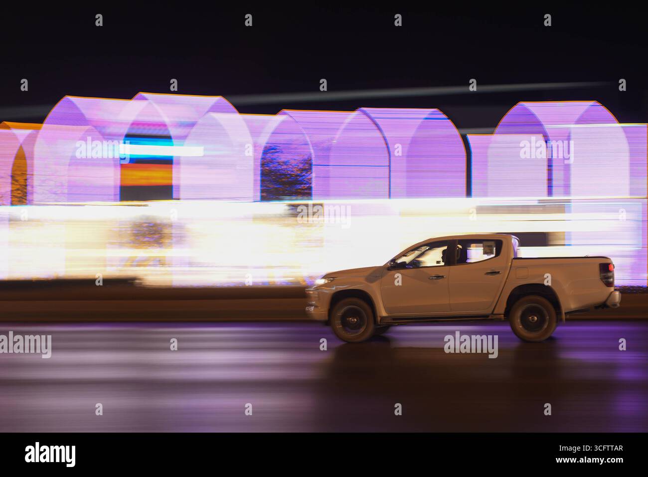 Riyadh di notte, Arabia Saudita Un veicolo viaggia lungo una strada di notte a Riyadh, Arabia Saudita, il 23 agosto 2025. La vibrante capitale dell'Arabia Saudita si trasforma drammaticamente di notte in una metropoli abbagliante illuminata da una vasta rete di luci. Essendo una delle città in più rapida crescita del Medio Oriente, la popolazione di Riyadh continua a gonfiarsi, guidata dalla diversificazione economica e dalle ambiziose iniziative Vision 2030. L'infrastruttura energetica di cityÕs si affida pesantemente a fonti sia tradizionali che rinnovabili per alimentare il suo vivace paesaggio urbano, riflettendo gli sforzi ArabiaÕs saudita per moderare Foto Stock