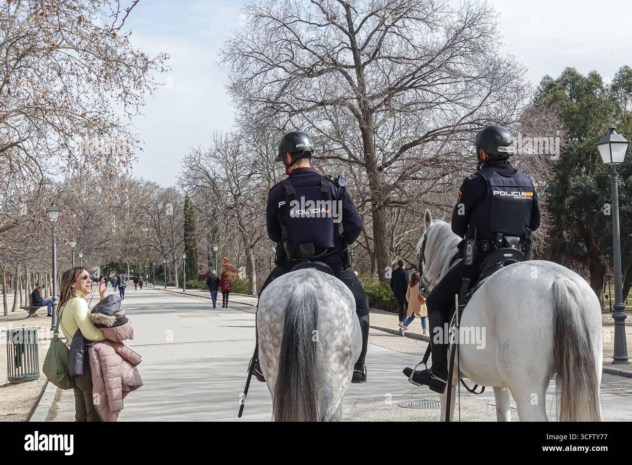 Poliziotti spagnoli a cavallo di pattuglia vicino a un monumento storico nel Parco El Retiro, Madrid, Spagna Foto Stock