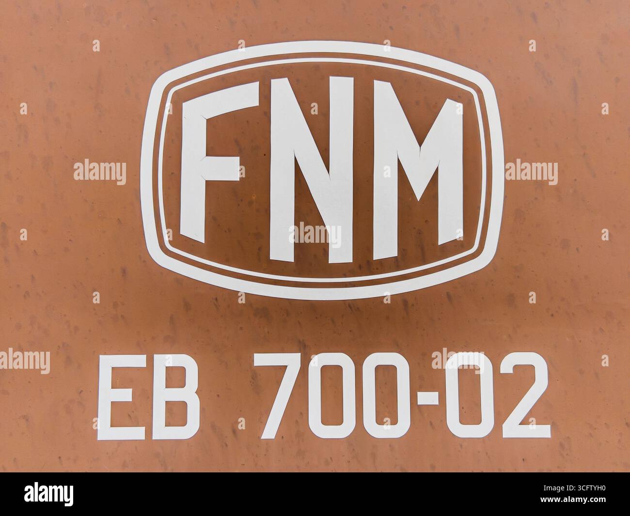 Savigliano, Italia - 24 agosto 2025: Logo vintage della FNM Ferrovie Nord Milano (Ferrovie Nord Milano) dipinto su un vecchio vagone marrone in disuso. Foto Stock