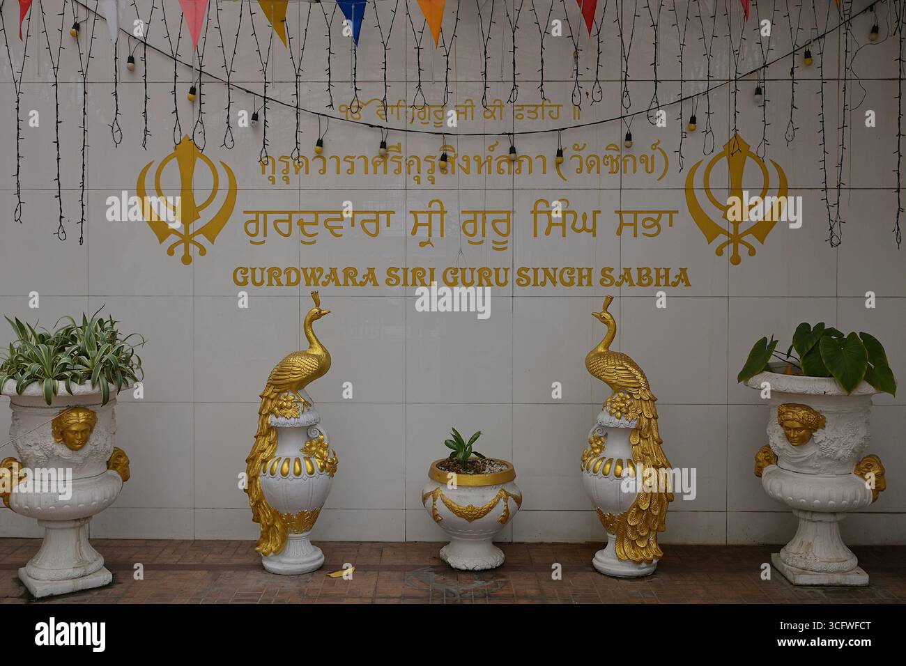 Segnaletica per il Tempio di Sri Guru Singh Sabha Gurdwara Sikh all'entrata lungo Chakkrapet Road a Phahurat, Bangkok Foto Stock