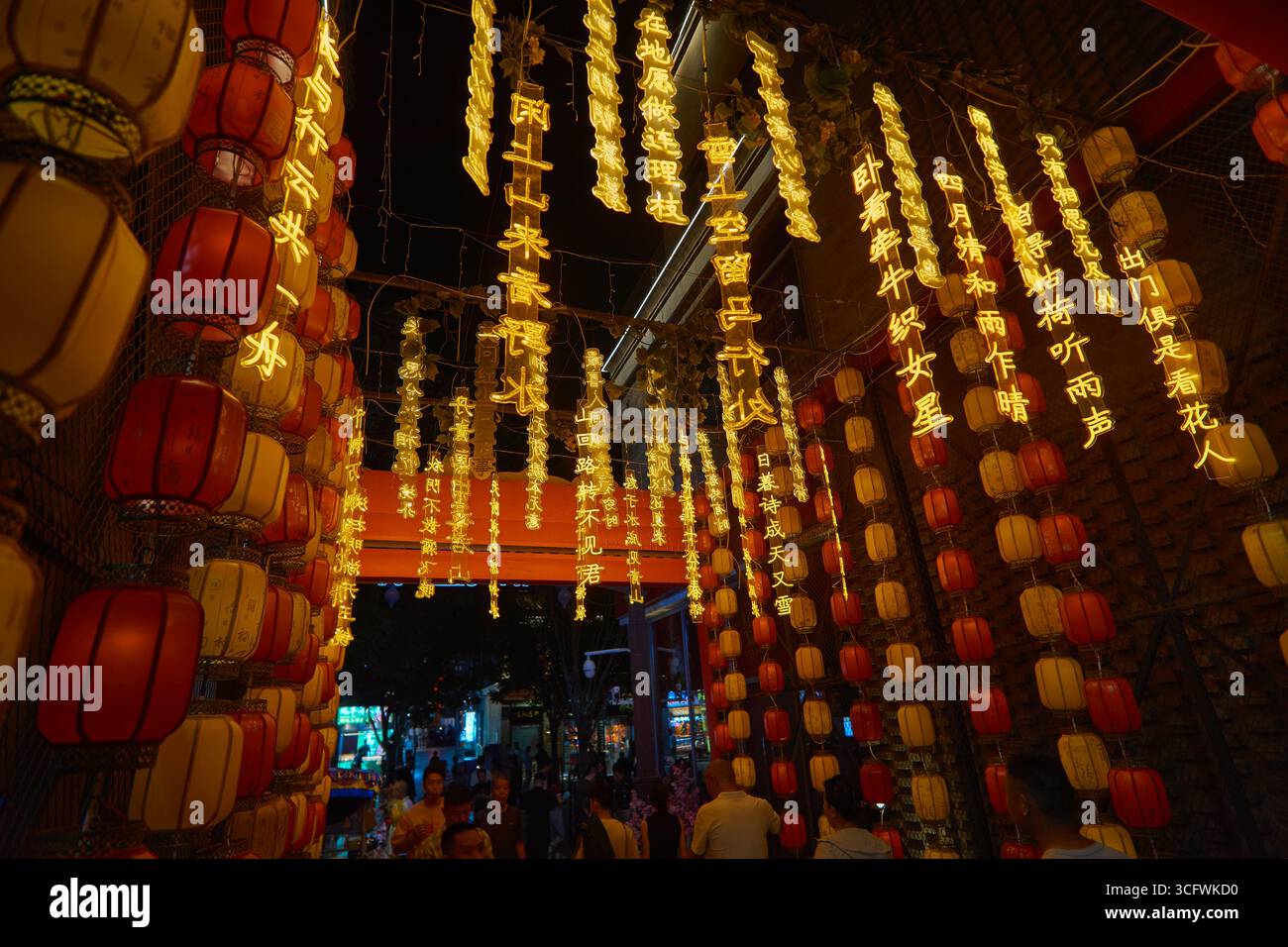 Decorazioni di strada con proverbi cinesi e lanterne rosse di notte in un hutong laterale di Qianmen Street, Pechino Foto Stock