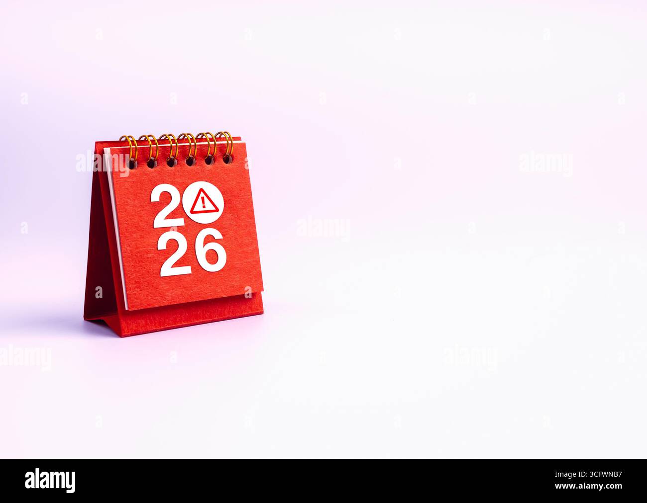 Calendario della scrivania rossa con l'anno 2026 e icona di avviso, che simboleggia la consapevolezza della truffa, il rischio di cybersicurezza, le frodi online, le minacce digitali, pericolo hacker, Foto Stock