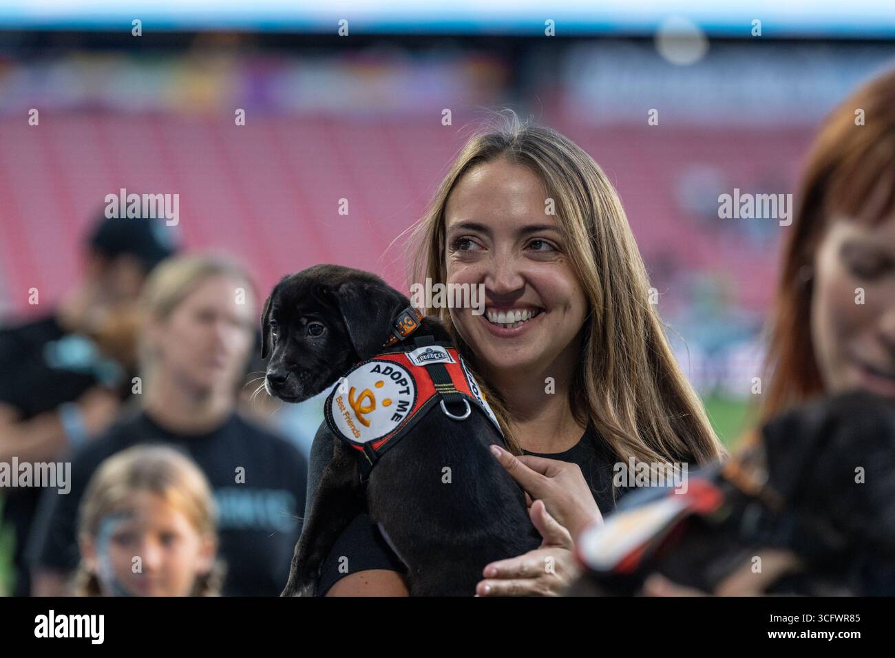 I tifosi con cani partecipano alla partita della NWSL di stagione regolare tra Gotham FC e Utah Royals allo Sports Illustrated Stadium di Harrison, New Jersey, il 23 agosto 2025. La partita si è conclusa con pareggio senza reti. La partita è stata pubblicizzata come "Dog Days of Summer" e i tifosi sono stati invitati allo stadio con i loro cani. Prima della partita i tifosi con i cani hanno sfilato intorno al campo. Foto Stock
