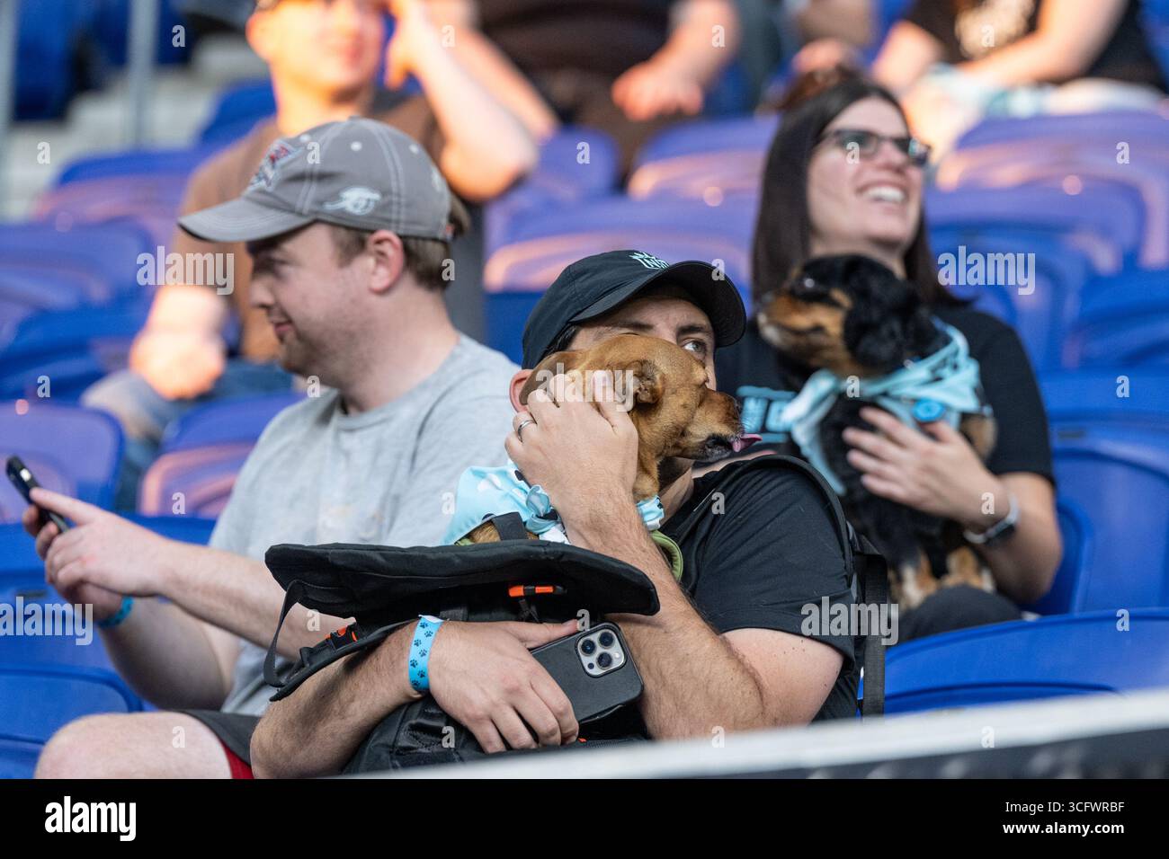 I tifosi con cani partecipano alla partita della NWSL di stagione regolare tra Gotham FC e Utah Royals allo Sports Illustrated Stadium di Harrison, New Jersey, il 23 agosto 2025. La partita si è conclusa con pareggio senza reti. La partita è stata pubblicizzata come "Dog Days of Summer" e i tifosi sono stati invitati allo stadio con i loro cani. Prima della partita i tifosi con i cani hanno sfilato intorno al campo. Foto Stock