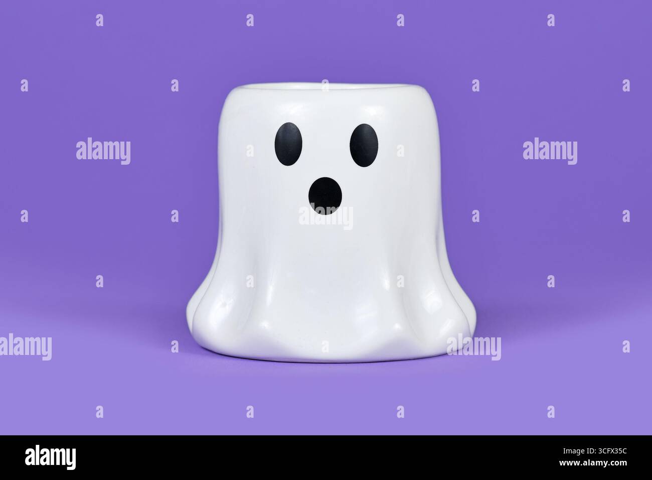 Ornamento bianco della candela fantasma di Halloween su sfondo viola Foto Stock