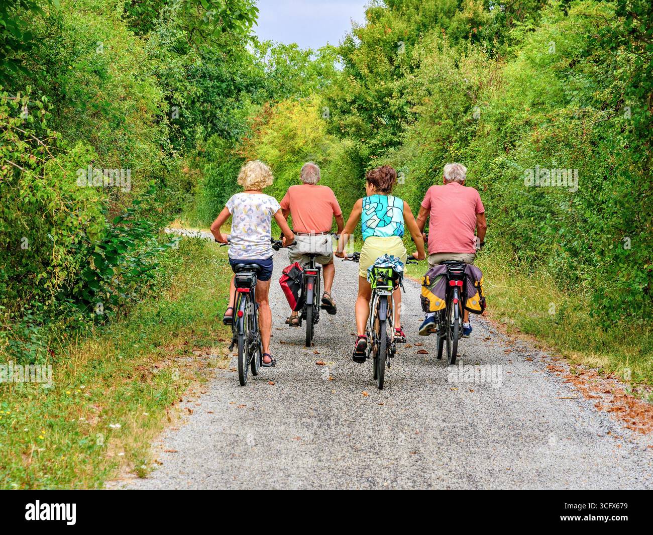 Amici in bicicletta sulla pista ciclabile verde "voie verte" senza traffico convertita dalla linea ferroviaria in disuso - Bossay-sur-Claise, Indre-et-Loire (37), Francia. Foto Stock
