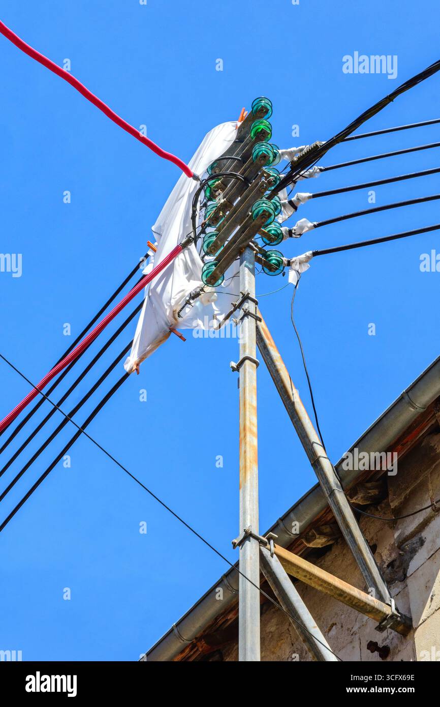 Vecchi isolatori elettrici in vetro protetti da lastre di plastica mentre i costruttori lavorano nelle vicinanze - Preuilly-sur-Claise, Indre-et-Loire (37), Francia. Foto Stock