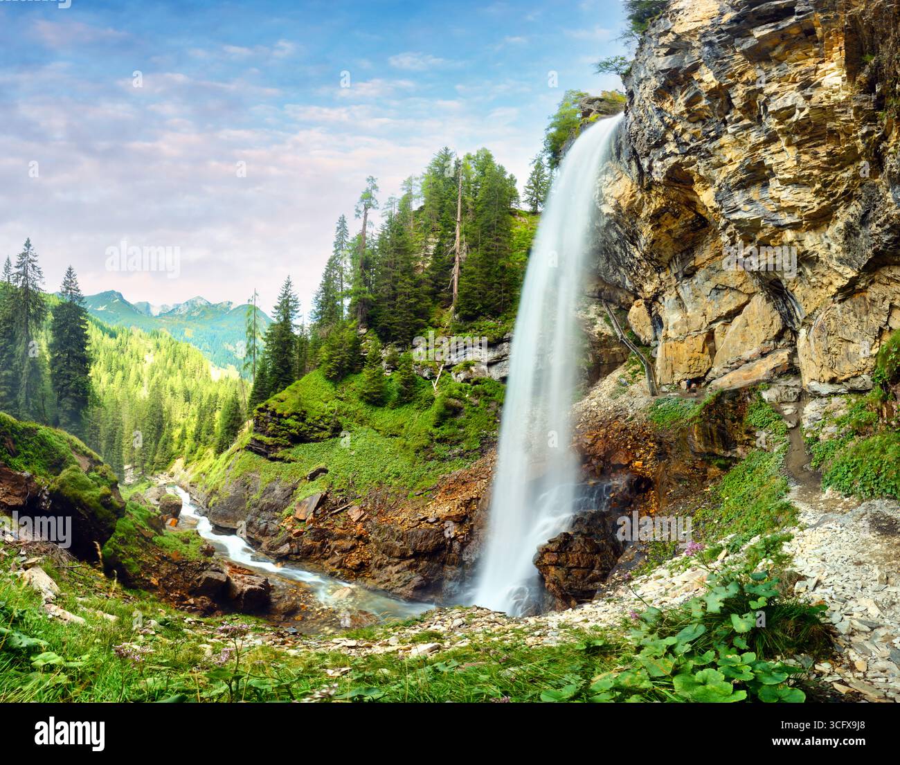 Cascate di Johannes splendidamente lungo le scogliere rocciose di Obertauern. Alberi torreggianti circondano l'area, creando un ambiente sereno perfetto per il n Foto Stock