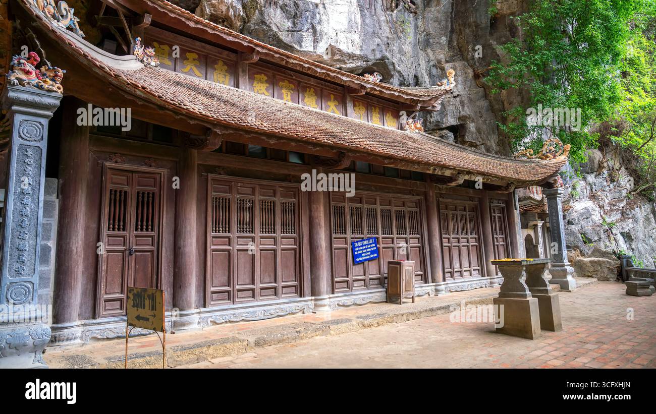 Annidata contro una scogliera calcarea, la Pagoda di Bich Dong è uno storico tempio del XV secolo costruito su tre livelli di una montagna carsica. Situato a Tam Coc Foto Stock