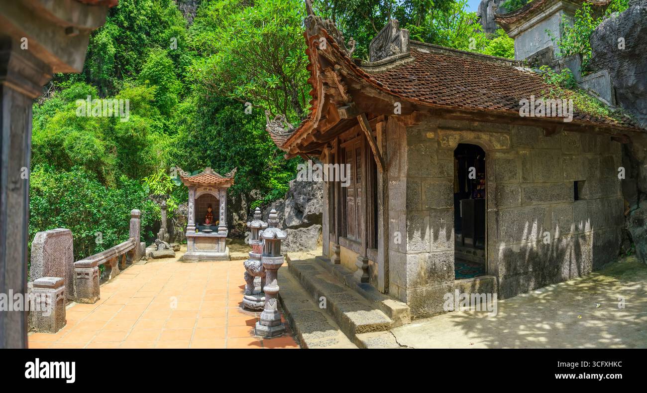 Annidata contro una scogliera calcarea, la Pagoda di Bich Dong è uno storico tempio del XV secolo costruito su tre livelli di una montagna carsica. Situato a Tam Coc Foto Stock