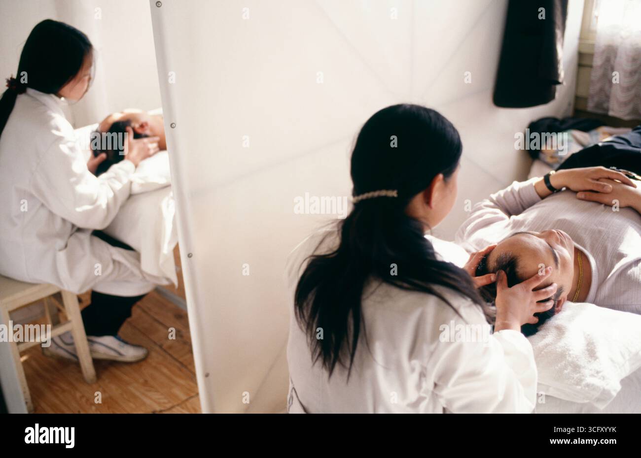 Massaggiatori femmina facendo massaggio testa a clienti in Cina Yunnan Foto Stock